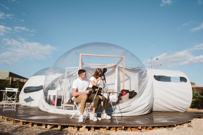 Young couple using astronomical telescope