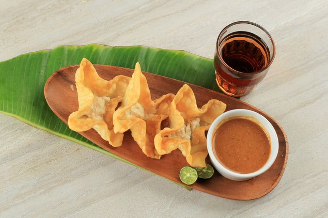 Top view of deep fried fish dumplings with peanut sauce and drink