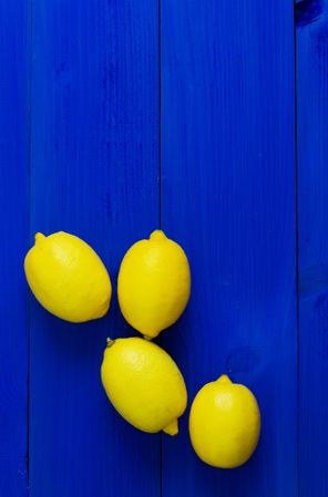 Four lemons on wood painted blue