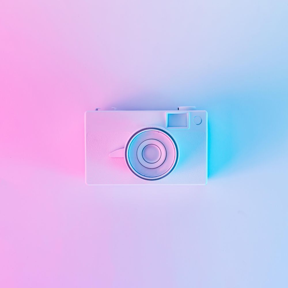Vintage camera in vibrant bold gradient purple and blue holographic colors