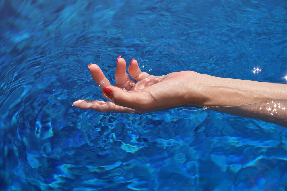 Crop woman in rippling pool water