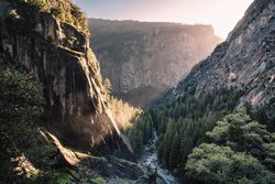 River between trees at foot of mountains