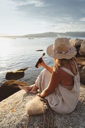 Woman relaxing and drinking beer at beach