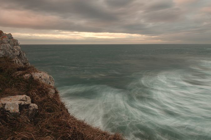 Powerful wave splashing at granite cliff