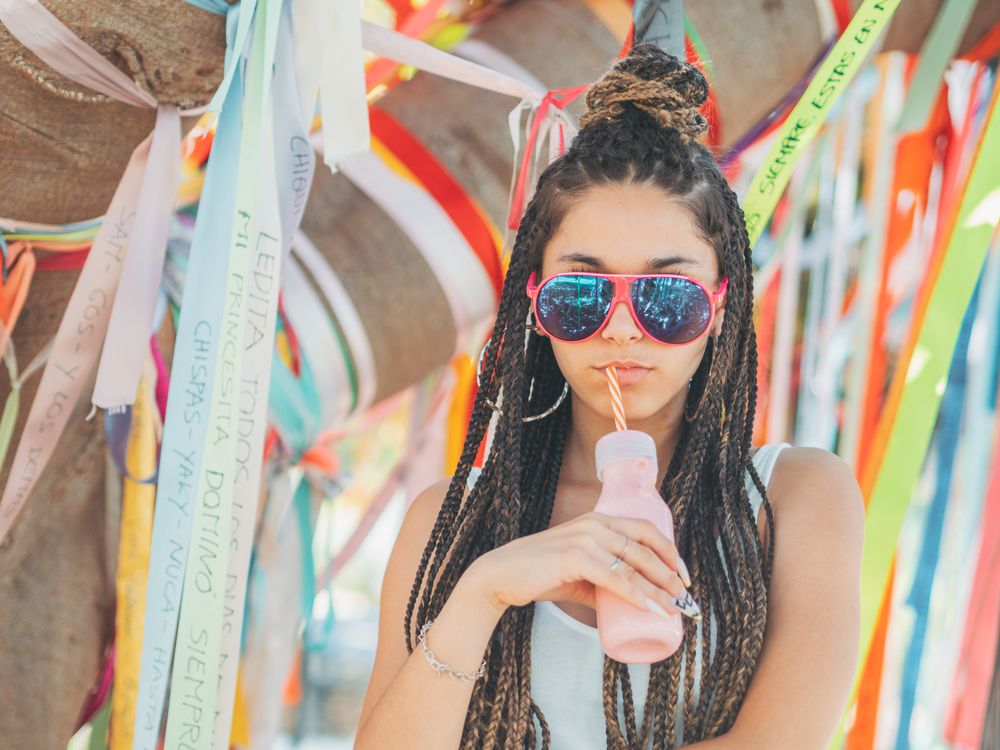 Trendy young woman enjoying beverage during party
