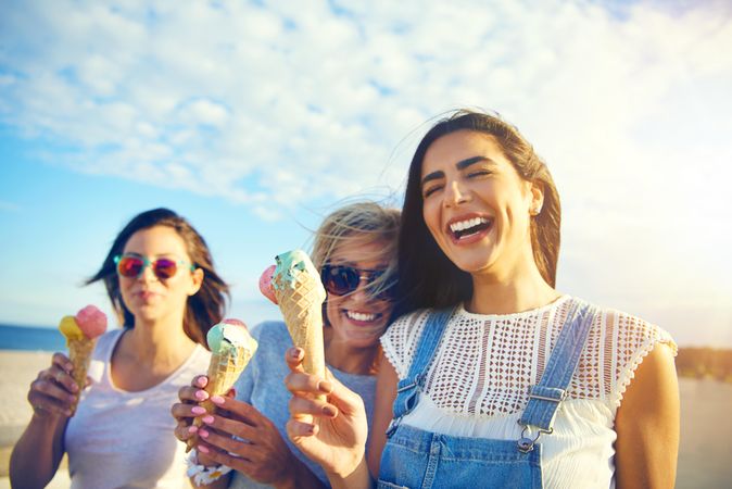 Joyful female friends eating ice cream in the sun