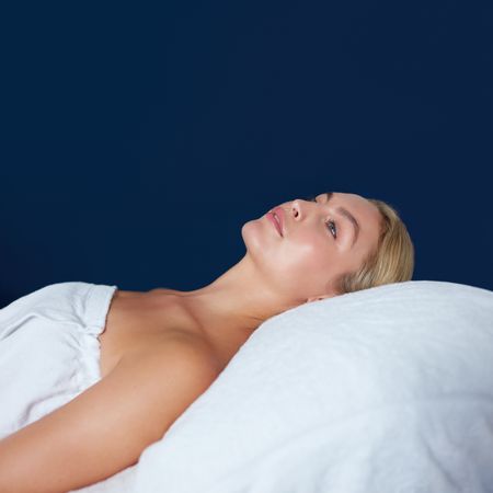 Blonde woman lying back during beauty treatment, square orientation