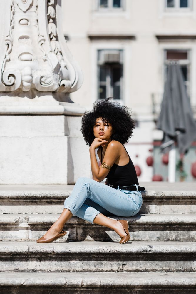 Black female siting on stairs outdoors