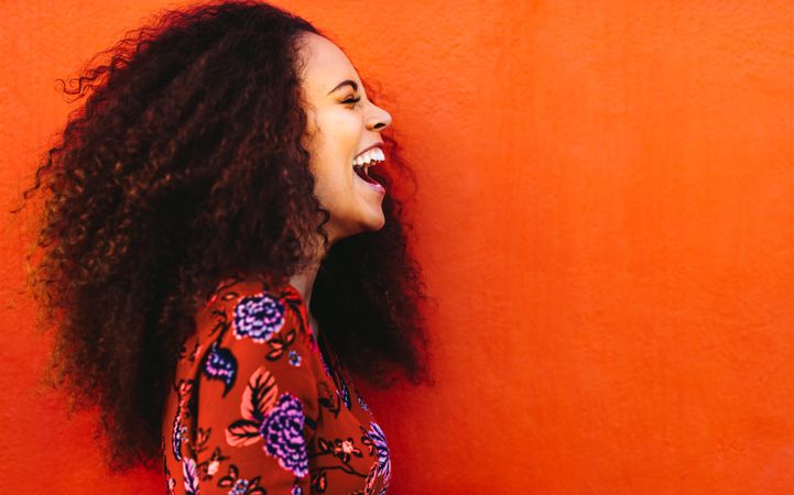 Close up of woman with curly hair laughing hysterically