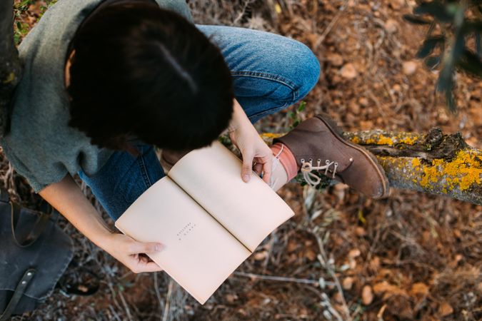 Above view of woman outdoors with book