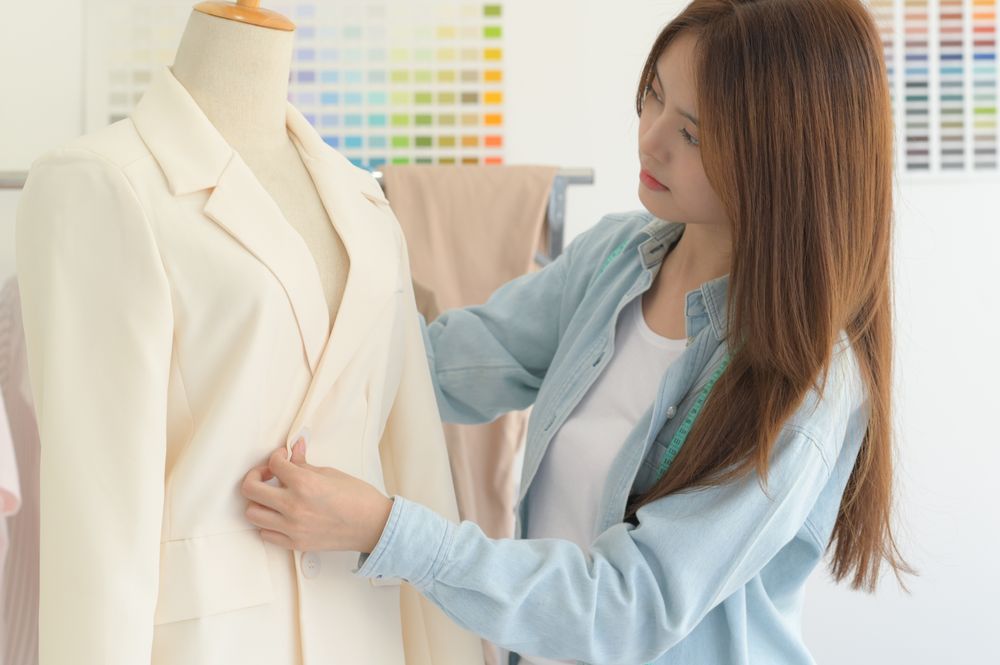 Young female tailor designer working with a tailor dummy in a workshop.