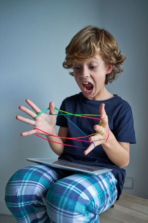 Boy screaming while playing string game