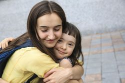 Two siblings being affectionate to one another