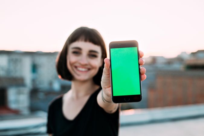 Smiling woman with smart phone outside