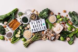 Arrangement of healthy vegan, plant based protein source and body building food with sign