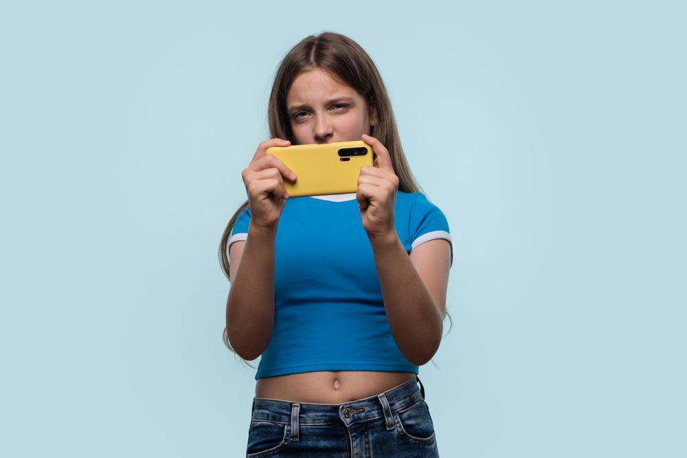 Girl concentrating intensely while holding smartphone