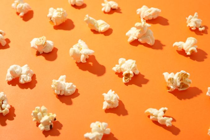 Flat lay composition with popcorn on orange background, closeup