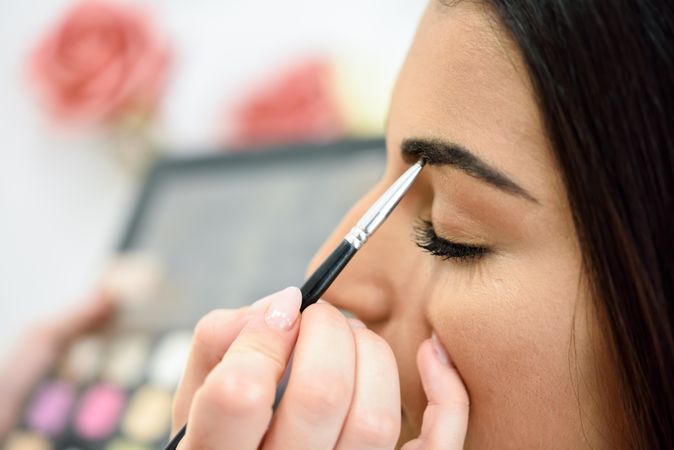 Brush applying make up to woman’s eyes
