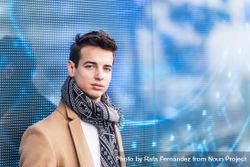 Portrait of handsome young man in fall coat against digital wall looking at camera 4mWEGz