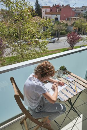 Kid painting on balcony of house