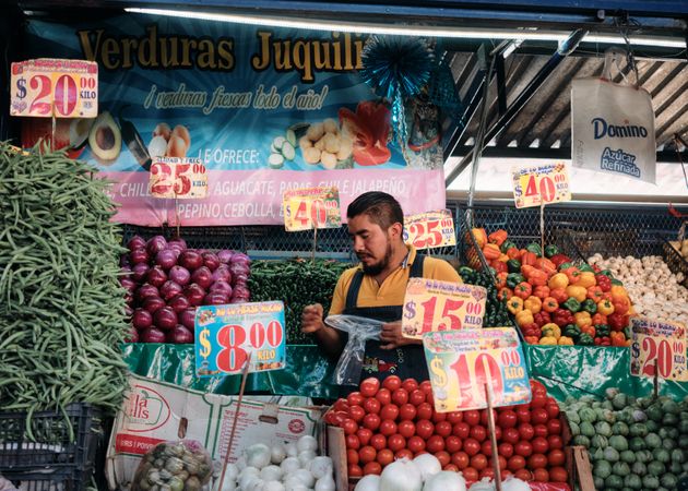 Man behind vegetable stall at market