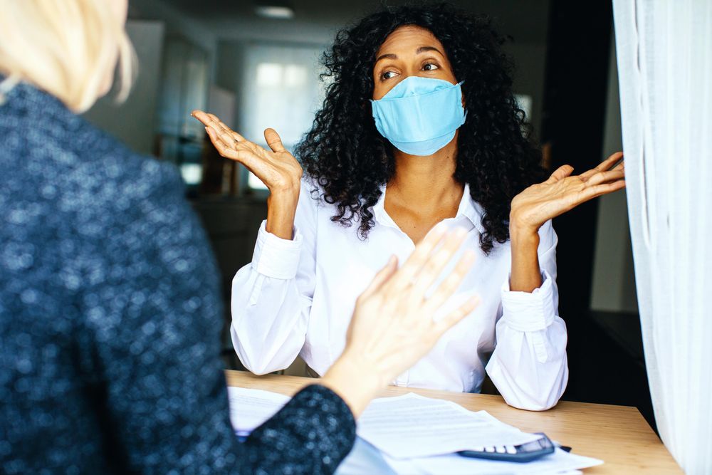 Two colleagues having an active discussion while wearing facemask