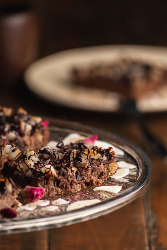Tasty brown cake decorated with flakes on glass plate
