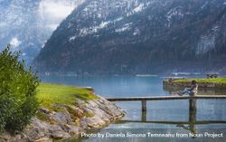 Woman sitting on a bridge over Hallstatter Lake in Austria bDmry0