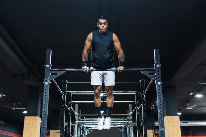 Hispanic sportsman exercising on crossbar