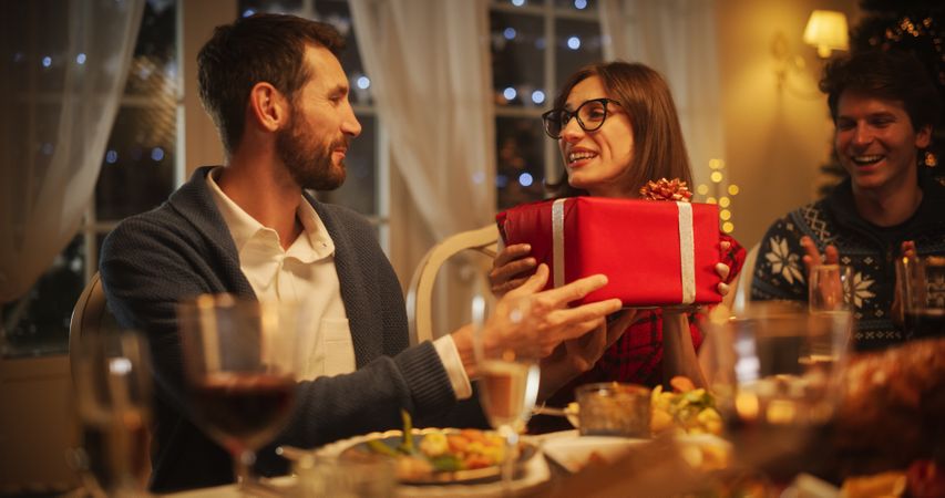 Boyfriend Presenting a Festive Gift to His Surprised Girlfriend.