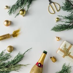 Christmas layout made of present, Champagne, branches, baubles on light background
