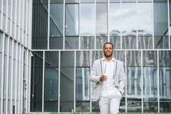 Black man with coffee standing in downtown