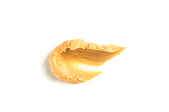 Creamy peanut butter isolated on bright background. A traditional product of American cuisine