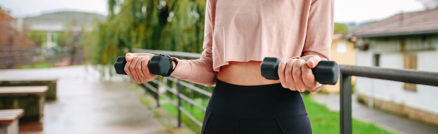 Young woman training with dumbbells