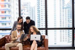 Businesspeople on leather couch discussing work