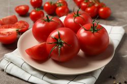 Composition with tomatoes on gray background. Ripe vegetable