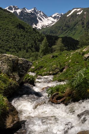 Snow-capped mountain with stream flowing