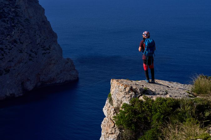 Traveler standing on top of mountain cliff