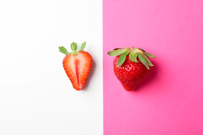 Strawberries on two color background, space for text. Summer sweet fruits and berries