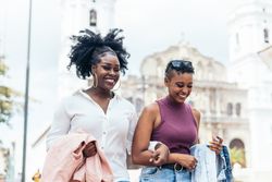 Black women talking and laughing walking in the city
