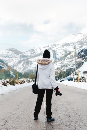 Anonymous person standing on road in countryside