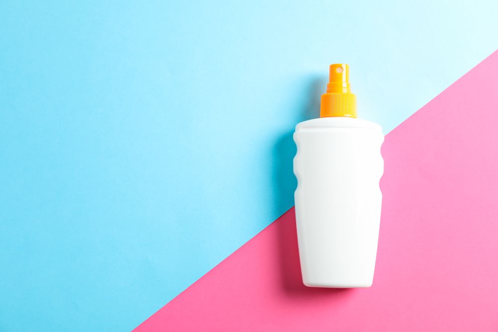 Sunscreen spray on two tone background, space for text