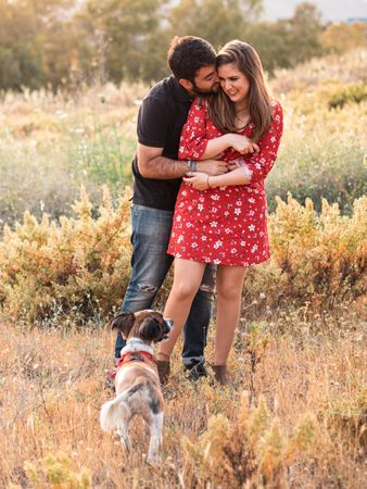 Happy couple with friendly cute dog outdoors