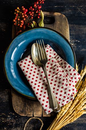 Autumn table setting with polka dot napkin, wheat and berry garnish
