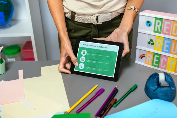 Teacher showing tablet with tips to be more ecological in environmental classroom