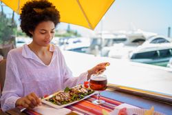 Woman eating a salad in waterfront cafe