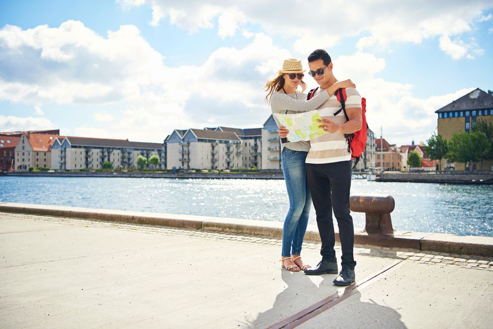Cute couple on vacation near a river checking a map