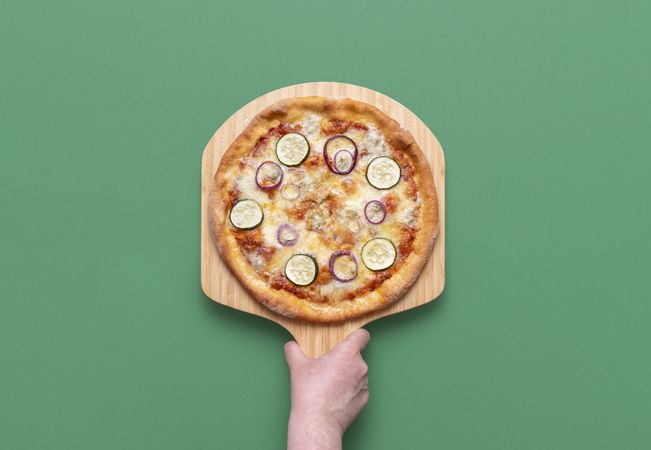 Vegetarian pizza top view on a green background