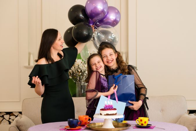 Mother and girls celebrating with birthday cake
