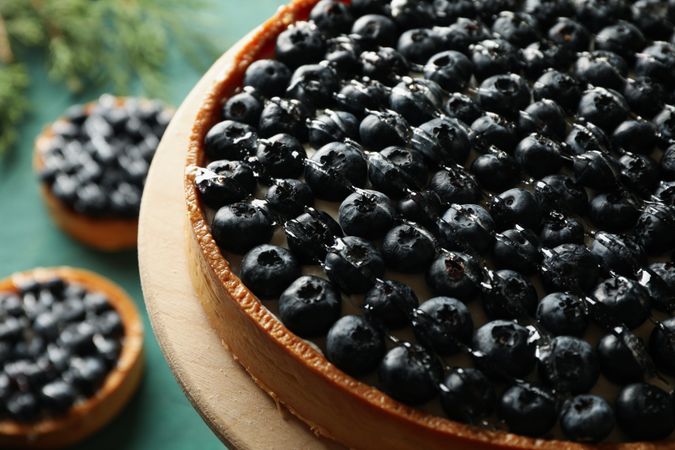 Concept of tasty lunch with blueberry pie on green background